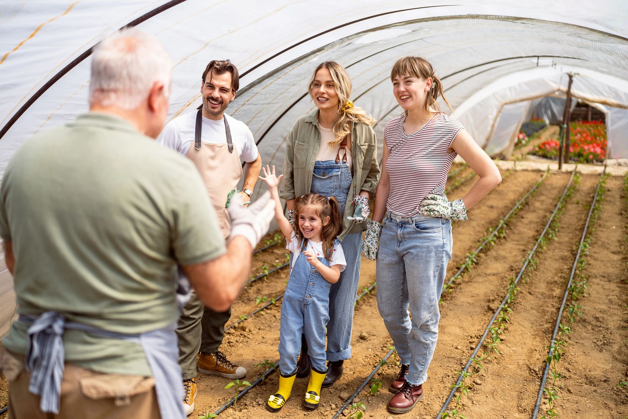 Farmer working in a greenhouse with family
