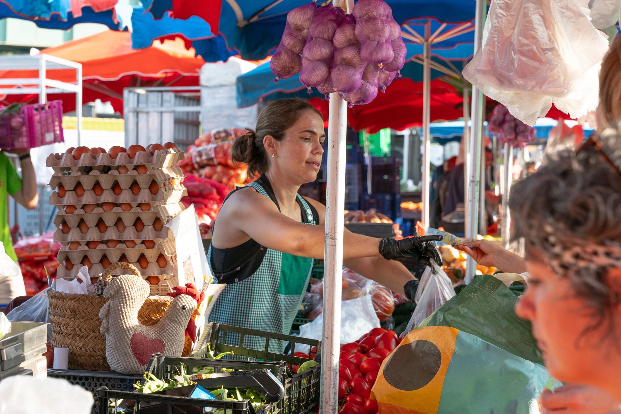 Vendor at a farmers market stall accepting payment