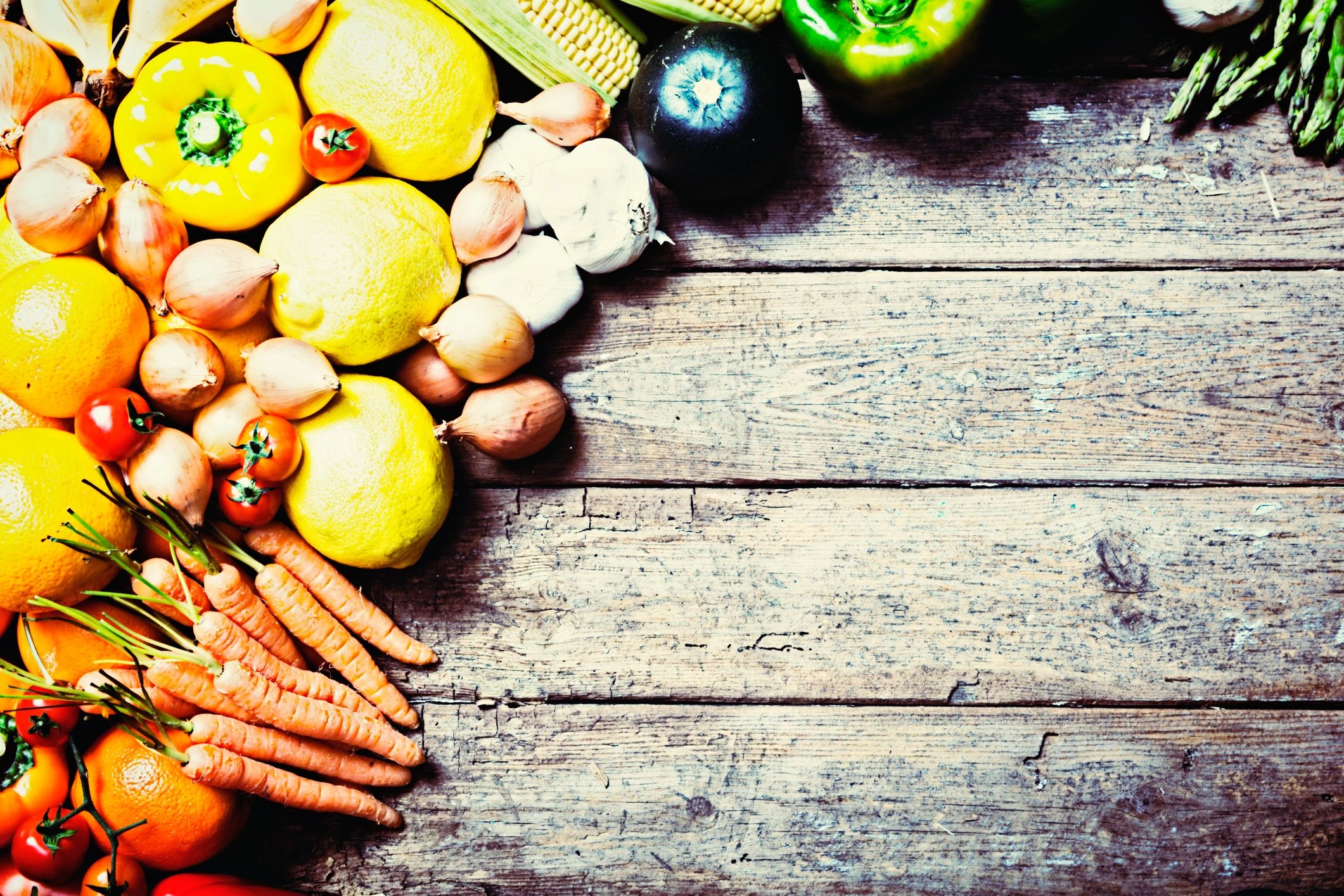 Border of abundant fresh vegetables on rustic wood